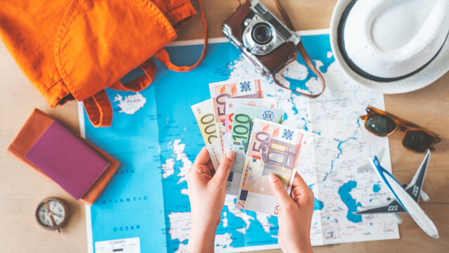 Woman holding money on travel background