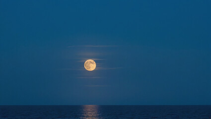 Full Blue Moon Rising Over Calm Ocean