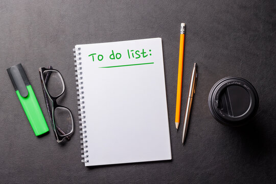 Organized work desk setup with office supplies, coffee, and a notepad for writing a to-do list