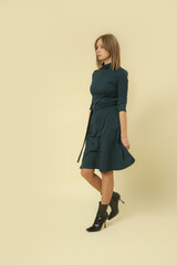 Serie of studio photos of female model in patterned green and black midi dress, autumn winter...