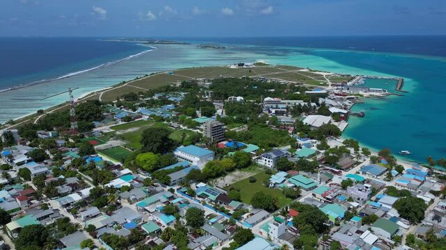 Hight angle view of Kaafu atoll at sunny day. Aerial view of Thulusdhoo island. Maldives. Tropical seascape of island in Indian Ocean under blue sky. High resolution video