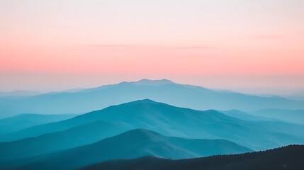 Fototapeta premium Ethereal mountain range panorama with soft pink sky at hazy sunrise