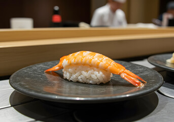 Shrimp Nigiri on a Black Plate: A Close-Up of Gourmet Sushi Prepared by a Chef in a High-End Restaurant