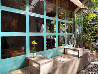 Outdoor seating outside of vintage home retro café with rustic wood and open pore wooden bench, vintage village home inside a jungle. Cozy corner