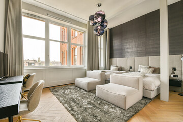 A chic and modern hotel room featuring large windows that allow natural light to fill the space, harmonizing style and comfort with elegant furnishings.