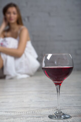 Woman and red wine. Depression, problems, consumption of alcoholic beverages. Female alcoholism. Glass of red wine.