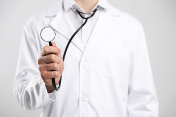 Doctor with stethoscope on light background, closeup