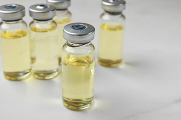Hepatitis vaccine in glass vials on white table, closeup. Space for text