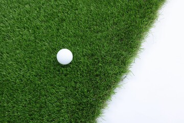 Golf ball and green grass on white background, top view. Space for text