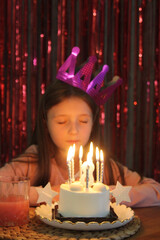 Girl celebrating birthday with cake and candles at home