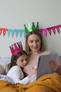 Family celebration with crowns and digital fun at home