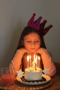 Child celebrating birthday with cake and candles