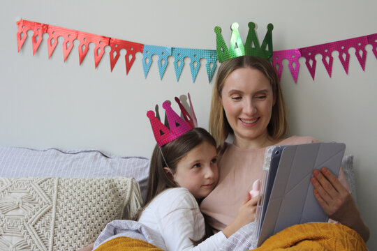 Mother and daughter enjoy cozy time together with tablet