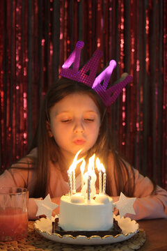 Little girl celebrates birthday with cake and candles