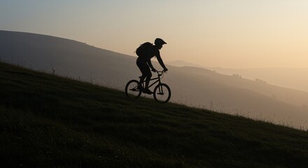 Fototapeta premium Silhouette of mountain biker enjoying a sunrise ride