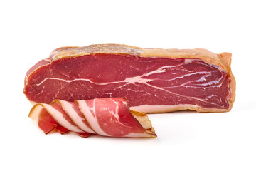 Piece of smoked prosciutto with slices, isolated on white background.