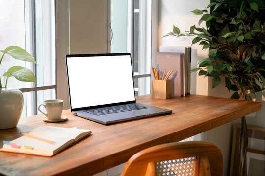 Laptop computer on wooden table, minimal home office concept.