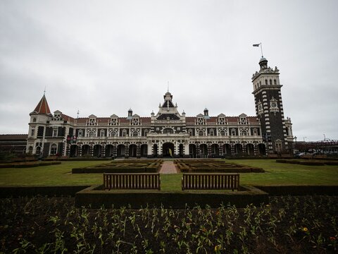 Historic Dunedin Railway Station building architecture infront of Anzac Square Gardens in Otago South Island New Zealand