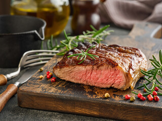 Beef Steak medium rare on black plate, surfed with tableware on black stone table with ample copy space. Dark background. Top view. Copy space.