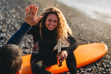 Happy young people, friends enjoying summer vacation with drink and surf at the beach