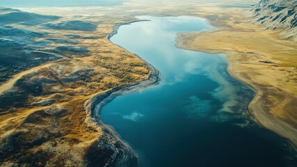 Fototapeta premium Aerial view of a stunning lake surrounded by golden autumn landscape.