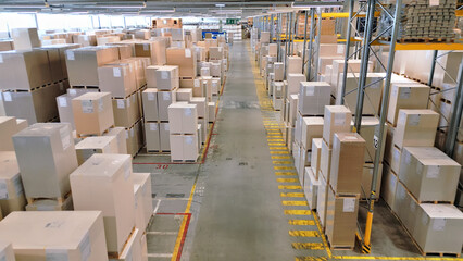 A vast warehouse filled with stacked boxes and crates symbolizes global supply chain logistics and...