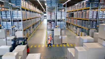 A bird's-eye view of a bustling warehouse reveals workers navigating aisles, highlighting the...