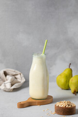 Refreshing pear and oat smoothie in glass bottle for healthy breakfast