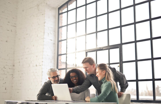 group of people in a modern industrial office working with a computer
