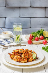 Grilled shrimp on a white plate with lime