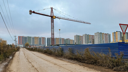 New buildings outside the city in Russia. Tower crane operation. Housing construction concept
