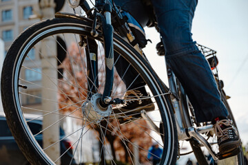 Naklejka premium A cyclist navigates through an urban area with a focus on the bicycle wheel
