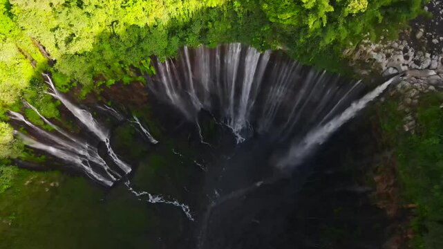 Aerial cinematic view of Tumpak Sewu waterfall, East Java, Indonesia &mdash; spectacular tropical cascade from drone.
