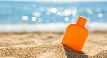 Bright orange sunscreen bottle resting in warm sand by the beach during a sunny day
