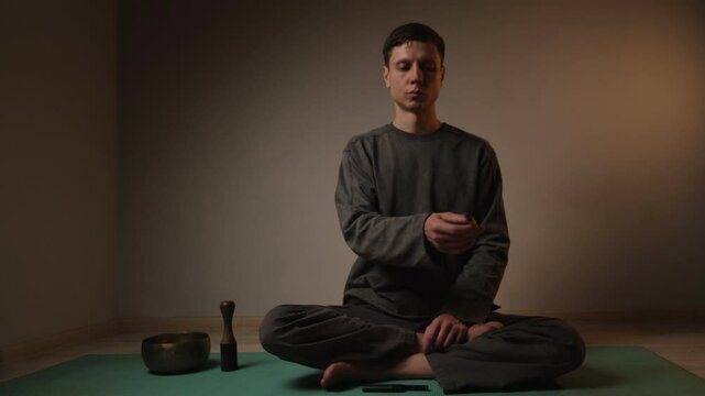 Person in the lotus pose holding wooden palo santo stick in the hand. Aroma therapy.