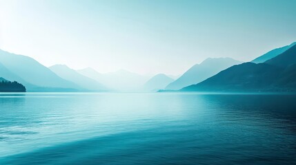 Tranquil lake scene with distant misty mountains.