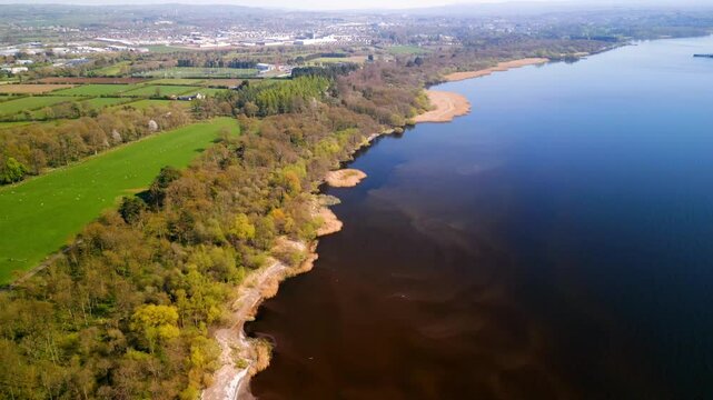 Forward travelling aerial of Lough Neagh and the Antrim coastline in County Antrim, Northern Ireland. Produced on a sunny summer's day in 4K, 60 frames per second and with Rec709 Color.
