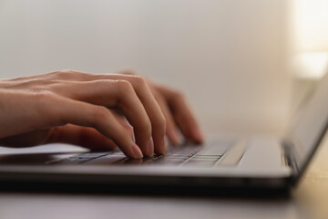 Hands typing keyboard on laptop with working online.