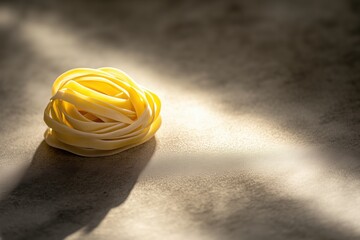 Raw fettuccine pasta nest, yellow strands, minimalistic presentation