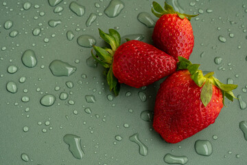 Freshly washed strawberries on a green background with water drops. Seasonal berries. Vitamins.