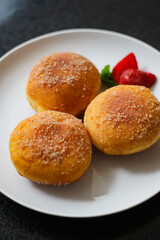 A handmade bombolone or bomboloni is an Italian-filled doughnut that is eaten as a snack or dessert. Selective focus.