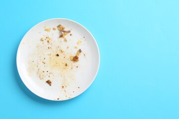 One dirty plate on light blue background, top view. Space for text