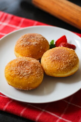 A handmade bombolone or bomboloni is an Italian-filled doughnut that is eaten as a snack or dessert. Selective focus.