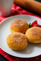 A handmade bombolone or bomboloni is an Italian-filled doughnut that is eaten as a snack or dessert. Selective focus.
