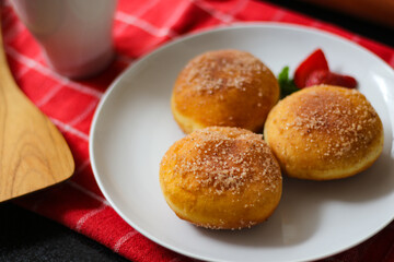 A handmade bombolone or bomboloni is an Italian-filled doughnut that is eaten as a snack or dessert. Selective focus.