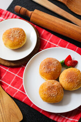 A handmade bombolone or bomboloni is an Italian-filled doughnut that is eaten as a snack or dessert. Selective focus.