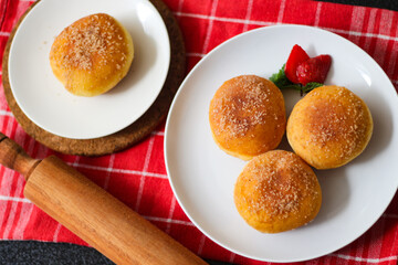 A handmade bombolone or bomboloni is an Italian-filled doughnut that is eaten as a snack or dessert. Selective focus.
