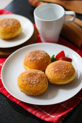 A handmade bombolone or bomboloni is an Italian-filled doughnut that is eaten as a snack or dessert. Selective focus.