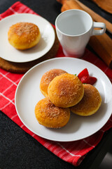 A handmade bombolone or bomboloni is an Italian-filled doughnut that is eaten as a snack or dessert. Selective focus.