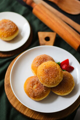 A handmade bombolone or bomboloni is an Italian-filled doughnut that is eaten as a snack or dessert. Selective focus.